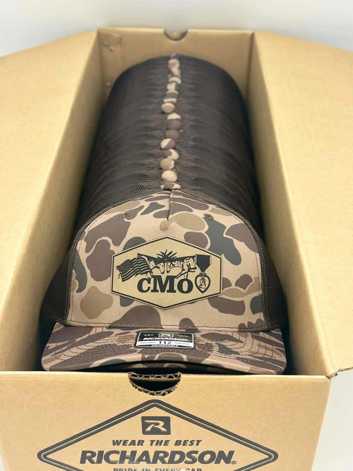 Camo hats with patches inside a box